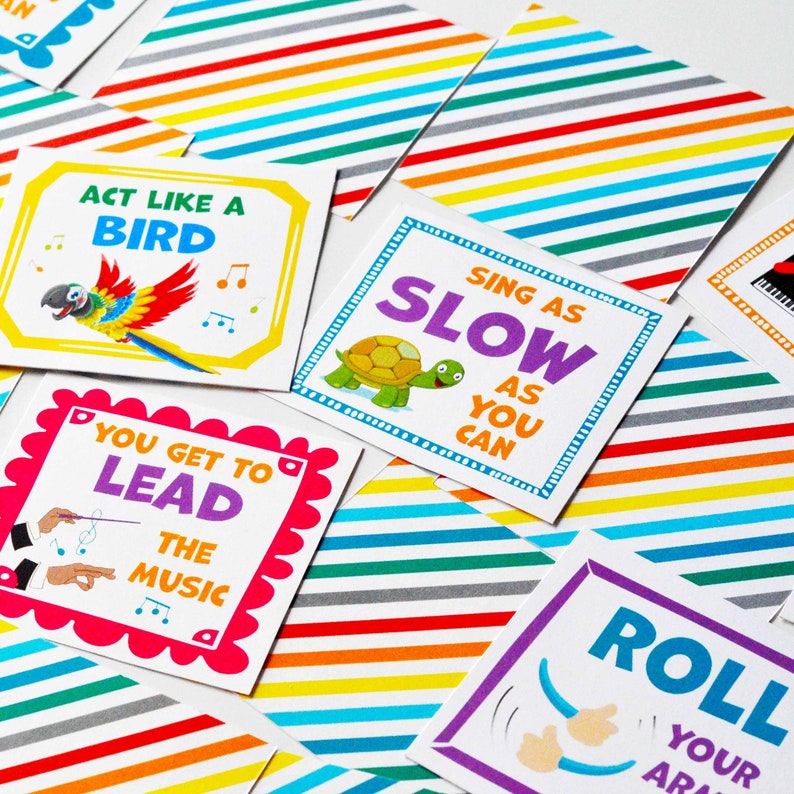 May include: A collection of square cards featuring colorful diagonal stripes and white centers with illustrations and text. Cards include phrases like Act Like A Bird, Sing As Slow As You Can, You Get To Lead The Music, and Roll Your Arms.