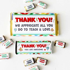 May include: Two chocolate bars with "THANK YOU!" in red text, surrounded by smaller candies with the same message. The bars have colorful borders and school-themed graphics, including pencils and globes. The larger bar says "WE APPRECIATE ALL YOU DO TO TEACH & LOVE."
