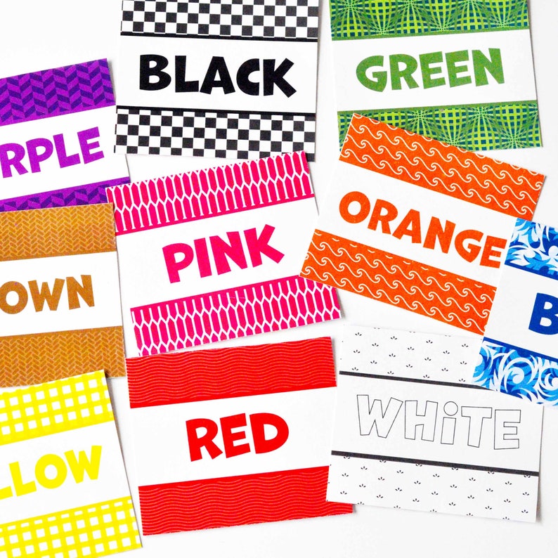 May include: A collection of rectangular cards featuring various colors and patterns. Each card displays the corresponding color name in bold text, including black, green, purple, pink, orange, brown, blue, yellow, red, and white.