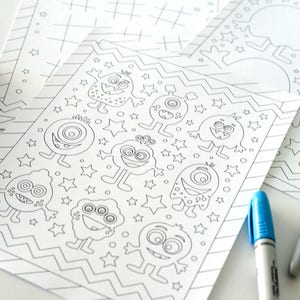 May include: A black and white coloring page featuring a variety of cute monsters with big eyes and different expressions. The monsters are surrounded by stars and a zig-zag pattern. The page is designed for children to color.