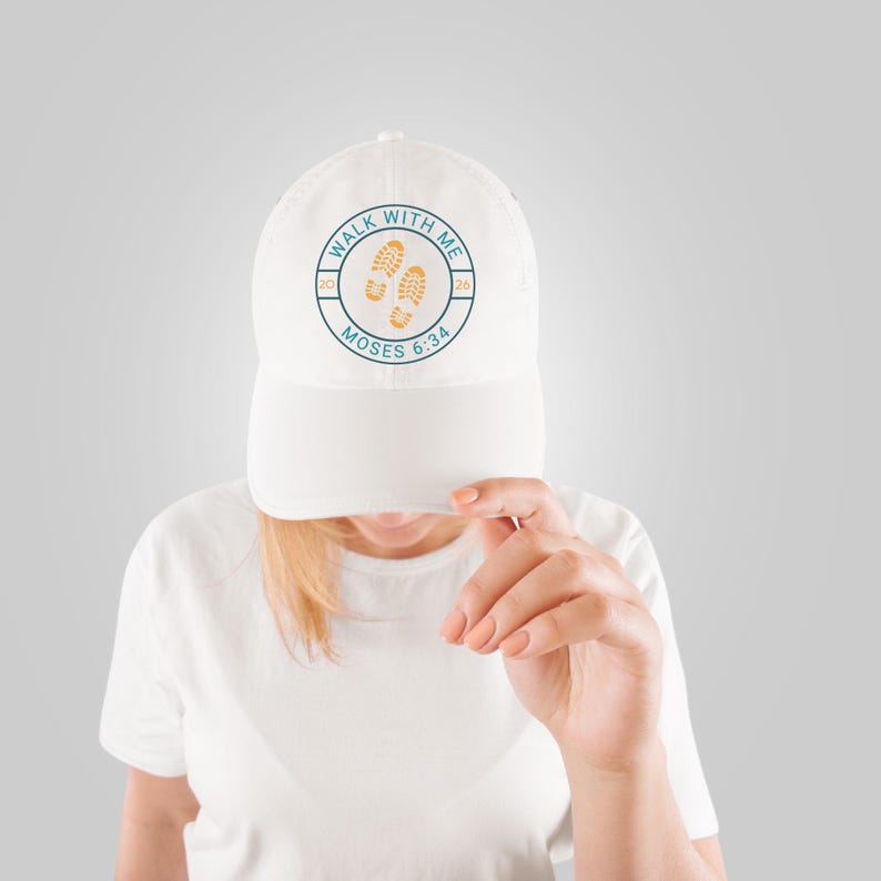 May include: White baseball cap with a curved brim. The cap features a circular design with the text "WALK WITH ME" and "MOSES 6:34" surrounding two footprints. The design is in teal and orange.