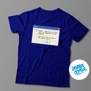May include: A royal blue t-shirt with a blue and white error message pop-up graphic that reads "ERROR: Something very bad has just happened to your computer. Have you tried turning it off and on again? OK".
