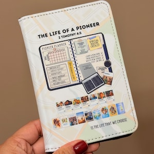 May include: A white and cream-colored planner with the text "THE LIFE OF A PIONEER" and "PIONEER PLANNER". The planner includes a calendar, checklist, and various images. The text "IS THE LIFE THAT WE CHOOSE" is also visible.