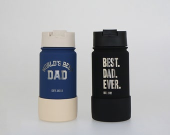 May include: Two stainless steel water bottles with a black lid and a silicone bottom. The blue bottle has the text "WORLD'S BEST DAD EST. 2012" and the black bottle has the text "BEST. DAD. EVER. EST. 2012".