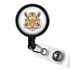 May include: Black retractable badge holder with a white circular design featuring a geometric tiger face.