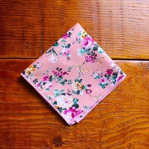 May include: A pink floral patterned handkerchief with a white border.