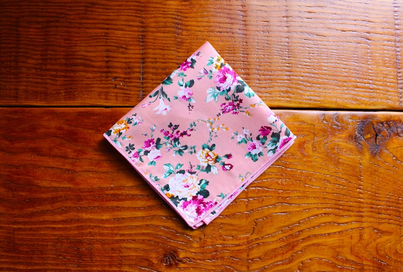 May include: A pink floral patterned handkerchief with a white border.