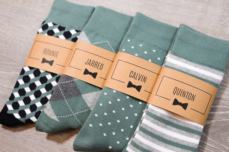 Four pairs of green socks with brown labels with black text