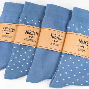 May include: Four pairs of blue socks with white polka dots and brown paper tags with names and titles like "Groom", "Best Man", and "Groomsman".