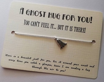 May include: A white string bracelet with a silver ghost charm. The card reads "A ghost hug for you! You can't feel it... but it is there!"  Here is a bracelet just for you, tie it around your wrist and every time you catch a glimpse, know I am sending a hug through the air to you!"