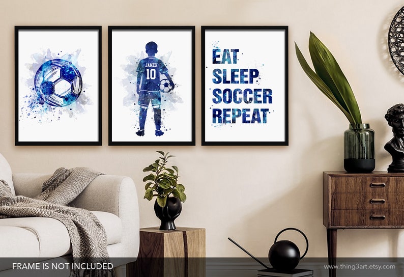 Pu&ograve; includere: Tre stampe ad acquerello con uno schema di colori blu e bianco. La prima stampa presenta un pallone da calcio, la seconda stampa presenta una silhouette di un calciatore con il nome "James" e il numero "10" sulla maglia, e la terza stampa presenta il testo "Mangia Dormi Calcio Ripeti".