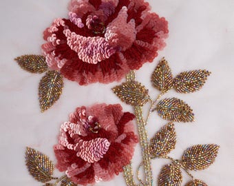 Hand-made motif of a sequined rose with brilliantly iridiscent leaves