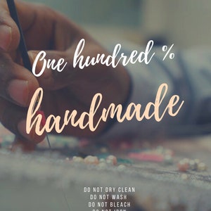 Może przedstawiać: Zbliżenie na rękę pracującą nad koralikowym elementem. Tekst "One hundred % handmade" jest widoczny nad ręką. Tekst "DO NOT DRY CLEAN, DO NOT WASH, DO NOT BLEACH, DO NOT IRON, PROFESSIONALLY SPOT CLEAN ONLY" jest widoczny pod ręką.