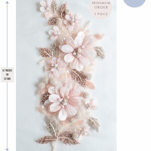May include: A delicate floral applique with pink and white flowers, silver and gold beads, and leaves. The applique measures 8.7 inches tall and 4 inches wide. Minimum order is 1 piece.