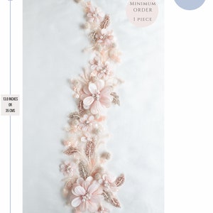 May include: A delicate floral applique with pink and white flowers and pearl accents. The applique measures 13.8 inches in length and 4 inches in width. Minimum order is 1 piece.