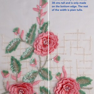 Pu&ograve; includere: Un delicato ricamo floreale rosa e verde su un tessuto bianco trasparente. Il ricamo &egrave; alto 38 cm e si trova solo sul bordo inferiore. Il resto del tessuto &egrave; tulle liscio.