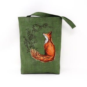 May include: A green linen tote bag with an embroidered fox design. The fox is orange and has a bushy tail. The embroidery is surrounded by a floral design.