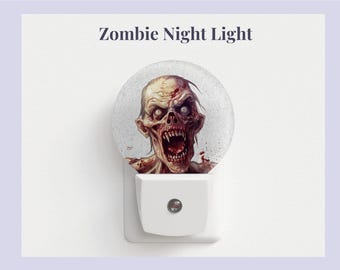 Pode incluir: Uma luz noturna branca de tomada com uma cúpula de plástico transparente que apresenta um gráfico de um zumbi com a boca ensanguentada e olhos vermelhos. O texto "Zombie Night Light" está impresso sobre a cúpula.