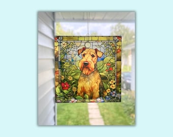 May include: A stained glass window hanging with a colorful image of a brown and tan Airedale Terrier dog sitting in a field of flowers. The flowers are red, yellow, blue, and purple.
