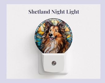 Pode incluir: Uma luz noturna branca com um design de vitral que apresenta um Shetland Sheepdog com um fundo de pôr do sol. O texto "Shetland Night Light" está impresso acima da imagem.