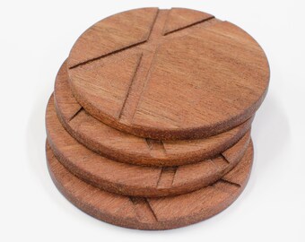 May include: Set of four brown wooden coasters with a geometric design. The coasters are stacked on top of each other.