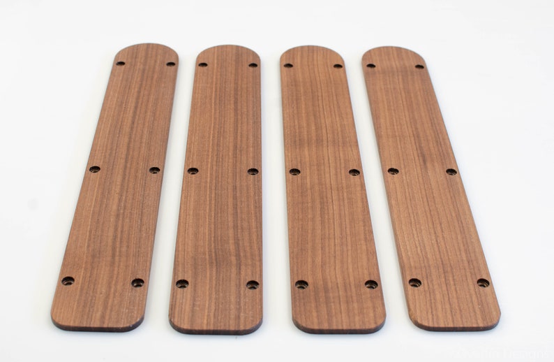 Puede incluir: Cuatro tiras de madera con bordes redondeados y varios agujeros perforados a lo largo de su longitud. Las tiras son de color marr&oacute;n claro y tienen un patr&oacute;n de veta de madera.