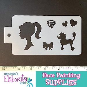 May include: A white face painting stencil with a girl's profile, a diamond, two hearts, a bow, and a poodle design. The stencil includes the text "Face Painting SUPPLIES" and the logo "amanda's Elaborate eyes".