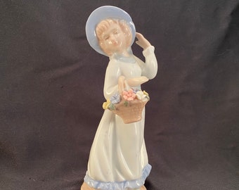 Estatueta vintage de porcelana representando uma menina com uma cesta de flores, escultura refinada.