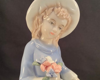 Statuetta vintage in porcellana raffigurante una ragazza con un bouquet di fiori.