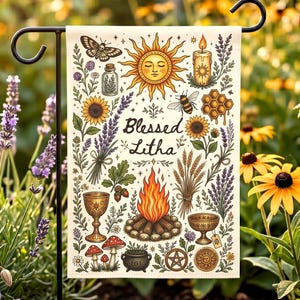 May include: A garden flag with a cream background features a sun, sunflowers, a bee, and the text "Blessed Litha." Other illustrations include a butterfly, candle, and a bonfire. The flag is displayed on a black metal stand, surrounded by flowers.