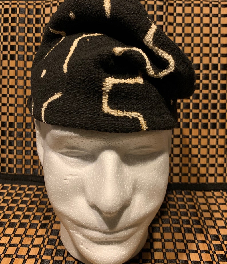 May include: A black and white patterned knit hat with a geometric design. The hat is folded over and has a soft, textured feel.