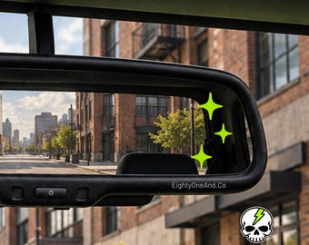 May include: A black rearview mirror featuring three bright green four-pointed star icons on the glass. The text EightyOneAnd.Co is printed on the mirror frame. A small white skull icon with a green lightning bolt is visible in the corner.