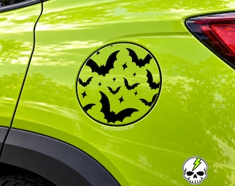 May include: A circular lime green decal featuring a repeating pattern of black bats and small four-pointed stars applied to a car fuel door. A small white skull icon with a green lightning bolt is visible below, and the text EightyOneAnd.Co is present.