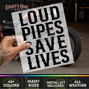 May include: A rectangular decal featuring the black text LOUD PIPES SAVE LIVES in a bold, serif font. The decal is held against a motorcycle background, with the brand name Eighty One & Co. visible in the top left corner and as a watermark.