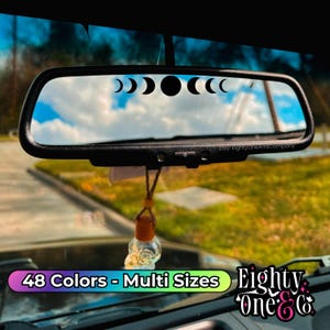 a rear view mirror with the reflection of the moon and the phases of the moon