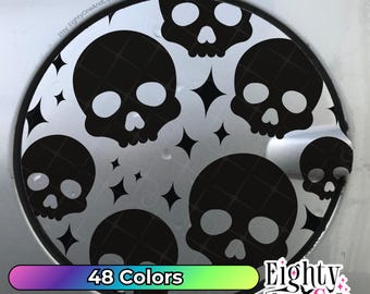 May include: A circular car gas tank cover decal featuring a repeating pattern of black skulls and four-pointed stars on a silver background. The text Etsy: EightyOneAndCompany is visible in the upper left corner of the circular design.