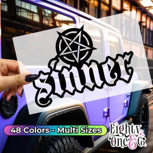 May include: A black and white vinyl decal with a pentagram and the word "Sinner" in a gothic font. The decal is on a blue car.