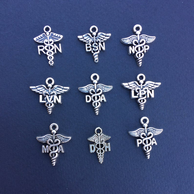 May include: Nine silver charms in the shape of the medical caduceus symbol with different medical abbreviations. The abbreviations include RN, BSN, NP, LPN, DA,  MHA, DOH, and PA.