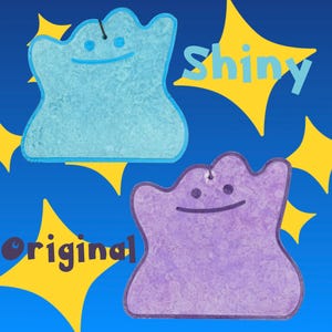 May include: Two amorphous, blob-shaped figures with simple dot eyes and a curved line for a mouth. One figure is light blue with the text Shiny nearby, and the other is purple with the text Original nearby. Both have a small hole at the top.
