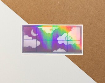 Puede incluir: Una pegatina holográfica con un diseño de marco de ventana. La ventana muestra un cielo nocturno con nubes y una luna creciente. La pegatina tiene un acabado iridiscente arcoíris.