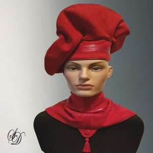 May include: A red felt hat with a leather band and a matching red leather scarf. The hat is styled with a unique, asymmetrical shape.