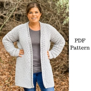 May include: A gray crochet cardigan with a long, open front. The cardigan is made with a textured stitch and has a relaxed fit.
