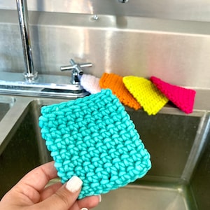 May include: A set of five knitted dishcloths in various colors, including turquoise, yellow, orange, pink, and white. The cloths are made of a soft, absorbent material and are perfect for cleaning dishes and countertops.