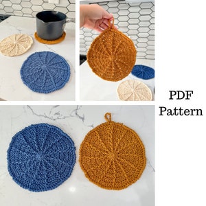 May include: Three crocheted pot holders in blue, beige and orange. The pot holders are round and have a textured design. The image also includes a black pot on a white counter.