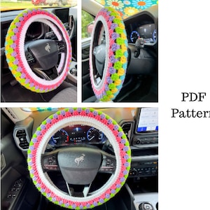 May include: A colourful crochet steering wheel cover in pink, green, yellow, and purple. The cover is on a car steering wheel.