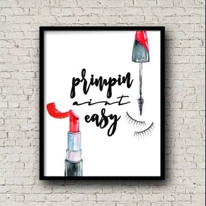 May include: A white background with black text that reads "Primpin' ain't easy". There is a red lipstick and a black mascara wand with lashes on the white background.