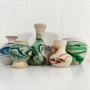 May include: A collection of five decorative vases with unique designs. The vases feature a variety of colors, including blue, green, and brown, with marbled patterns. The vases vary in shape and size, adding to their artistic appeal.