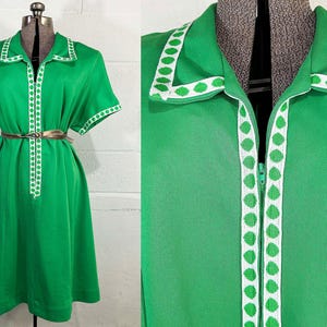 May include: A bright green short-sleeved dress featuring a front zipper closure and a white collar trim with a repeating green leaf pattern. The dress includes matching white and green leaf-patterned trim along the sleeve cuffs and a thin metallic belt.