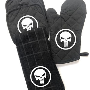 Punisher grill set, one glove mitt, one towel, and two pot holders