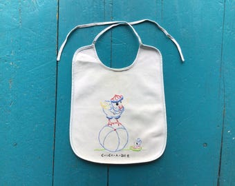Babador antigo bordado para bebê com a estampa "Chick-A-Dee", década de 1930-1940.